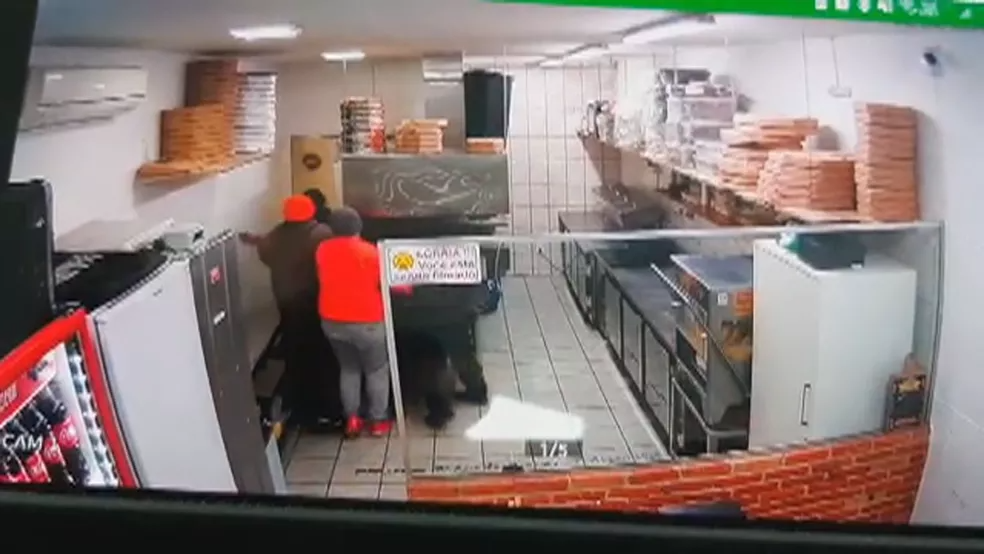 Câmeras mostram grupo cercando policial atrás de porta em pizzaria de Porto Alegre — Foto: Reprodução/RBS TV