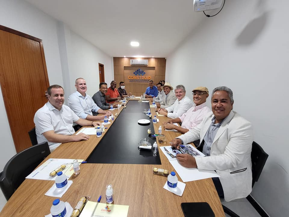 Pode ser uma imagem de 7 pessoas, pessoas sentadas, pessoas em pé e área interna